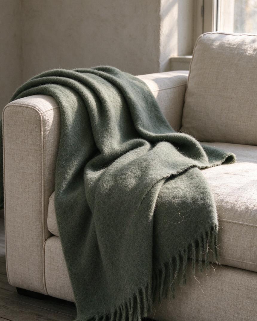 A wool throw folded over a sofa arm